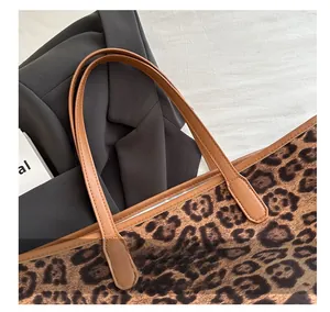 Close-up of leopard print tote bag featuring premium brown leather handle and stitching