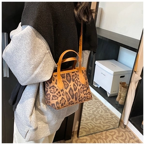 Dettaglio della borsa a secchiello leopardata con manici in pelle e tracolla regolabile