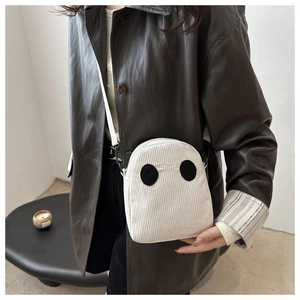 Sac bandoulière fantôme en velours côtelé blanc porté par un mannequin