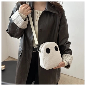 Détail du sac à bandoulière en velours côtelé blanc avec motif fantôme sur veste