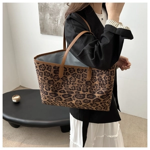 Detail of leopard print tote bag with brown leather handles and spacious interior lining
