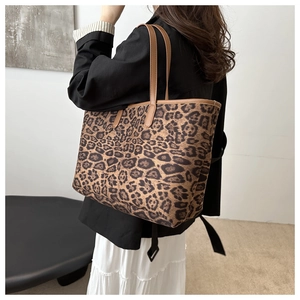 Detailed view of the leopard print tote bag featuring brown leather shoulder straps