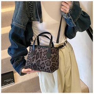 Dettaglio borsa a secchiello leopardata con bordi in pelle nera e fibbie metalliche