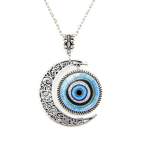 Macro detail of silver crescent moon necklace with blue evil eye glass pendant charm