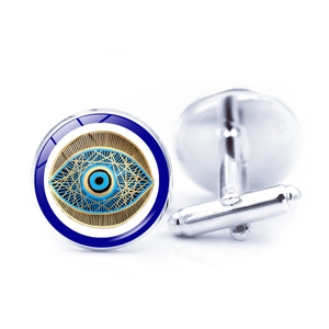Macro view of blue evil eye cufflinks showing polished silver T-bar closure and round pattern