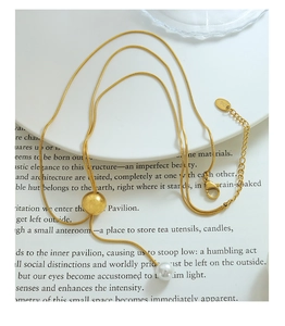 Détail du collier chaîne serpent dorée avec perle et perle dorée mate en pendentif Y