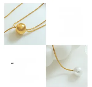 Détail de la chaîne serpent en titane plaqué or 18K avec pendentif perle et bille dorée