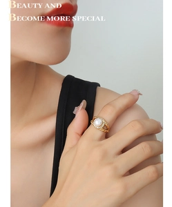 Detailed shot of gold twisted rope ring featuring a freshwater pearl and zircon halo