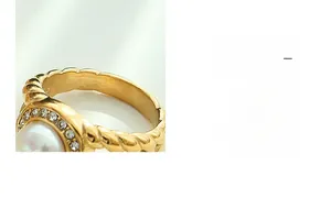 Macro view of gold twisted ring featuring a white pearl and sparkling zircon halo