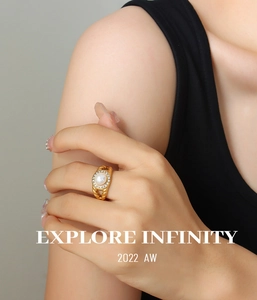 Detail of gold-plated twisted ring featuring a freshwater pearl and zircon stones