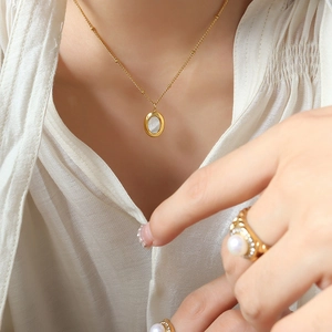 Conjunto de collar de titanio dorado con colgante de nácar y anillo de perla