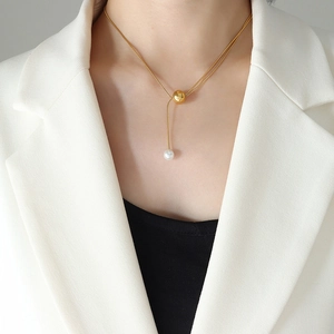 Collier élégant en chaîne serpent dorée avec pendentif perle porté par un mannequin
