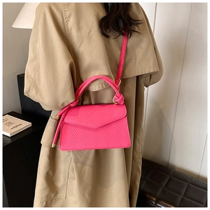 Bright pink crossbody bag with woven handle and embossed leather in high fashion style