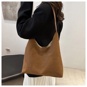 Detail of vintage brown suede hobo tote showing soft texture and half-moon silhouette