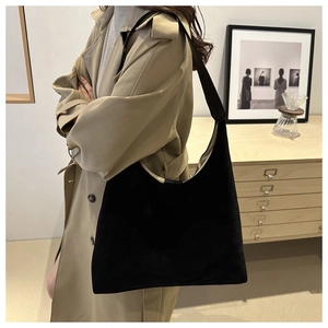Detail of a large black suede hobo shoulder bag with a premium smooth matte texture