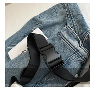 Close-up of durable black nylon strap with high-strength plastic buckle on denim background