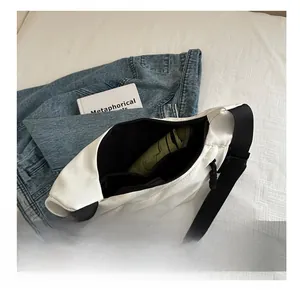 Internal view of white nylon crossbody bag showing storage capacity for a folding umbrella