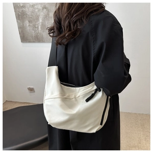 Detailed back view of minimalist white nylon crossbody tote bag with wide black strap