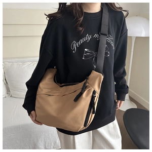 Detail of camel nylon crossbody bag with adjustable wide strap and black zipper features