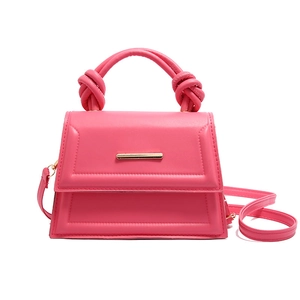 Hot pink trapezoidal handbag with knotted handle and gold metal bar buckle on white background