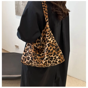 Detail shot of a large leopard print tote bag with a soft texture and wide shoulder strap