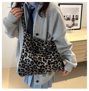 Détail d'un grand cabas en toile à imprimé léopard porté en bandoulière pour un look chic