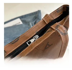 Macro shot of silver zipper on brown leather tote with contrast stitching