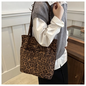 Dettaglio della borsa tote leopardata con due tasche frontali e morbida pelle scamosciata