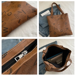 Detail view of brown letter print tote bag showing leather texture and spacious interior
