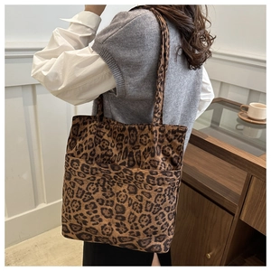 Vista laterale della borsa tote leopardata con doppi manici e tasca frontale