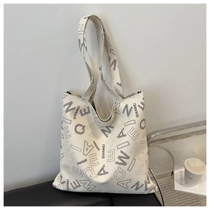 Close-up of cream tote bag featuring black QIANWEI letter print and soft leather texture
