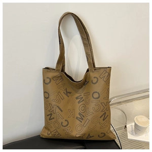 Close-up of brown tote bag with black letter prints and high-quality leather texture