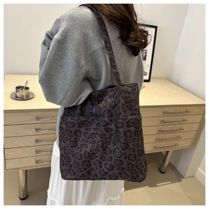 Vista dettagliata della borsa tote leopardata grigia con tasca frontale indossata