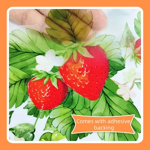 Detail of strawberry wall sticker being peeled to show transparent adhesive backing