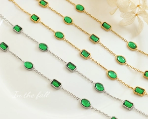 Detail of gold and silver plated bracelets with green emerald zircon in a diagonal layout