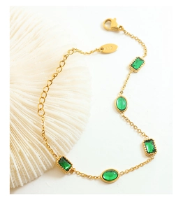 Detail of 18K gold bracelet featuring emerald green rectangle and oval zircon stones