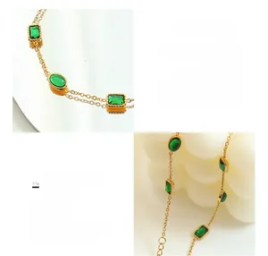Detailed close-up of 18K gold plated titanium bracelet with emerald cubic zirconia charms