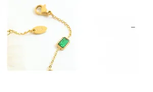 Detail of 18K gold chain bracelet with emerald zircon and lobster clasp closure