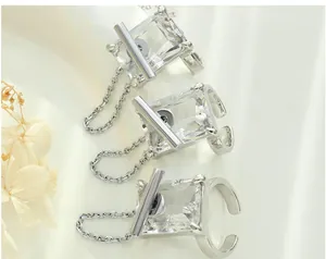 Close-up of three silver rings with rectangular zircon stones and side chain details