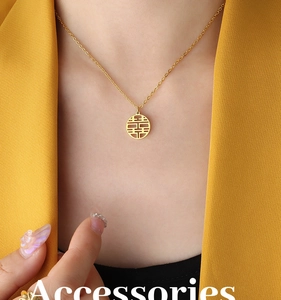 Close-up of gold double happiness xi character pendant necklace on a female model