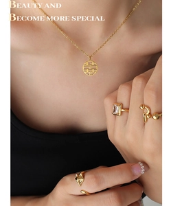 Detail view of gold double happiness pendant necklace and matching designer rings