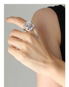Macro detail of silver ring featuring a large rectangular zircon with industrial chain link
