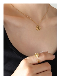 Detail view of gold double happiness pendant necklace and adjustable fox head ring