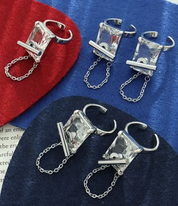 Macro detail of silver adjustable ring featuring a large rectangular zircon and chain fringe