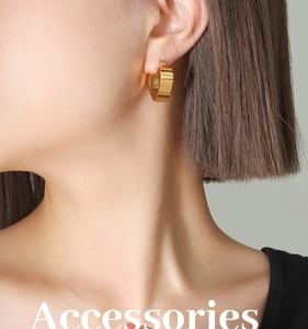Polished 18K gold heart-shaped hoop earrings shown on model for minimalist style