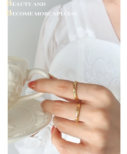 Detail of gold thin rings with star-set colorful zircon stones worn by a model