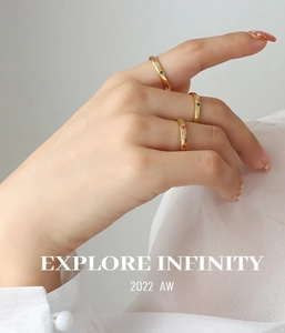 Detail of gold stacking rings featuring colored zircon stones on white silk fabric