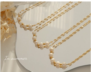 Détail du collier de perles d'eau douce avec perles dorées sur miroir et lumière douce