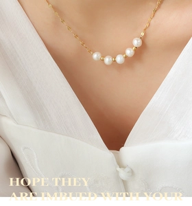 Vue détaillée du collier en perles dorées sur un mannequin en vêtements de soie