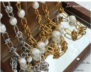Macro detail of thick chain jewelry sets with freshwater baroque pearls and knot links